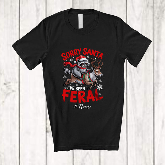 MacnyStore - Personalized Custom Name I've Been Feral; Amusing Christmas Santa Raccoon Riding Reindeer T-Shirt