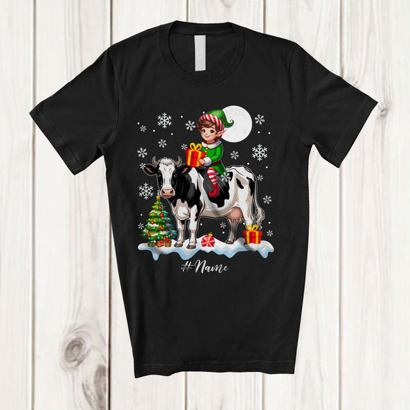 MacnyStore - Personalized Custom Name Elf Riding A Cow; Amazing Christmas Snowing Cow Farm Farmer T-Shirt
