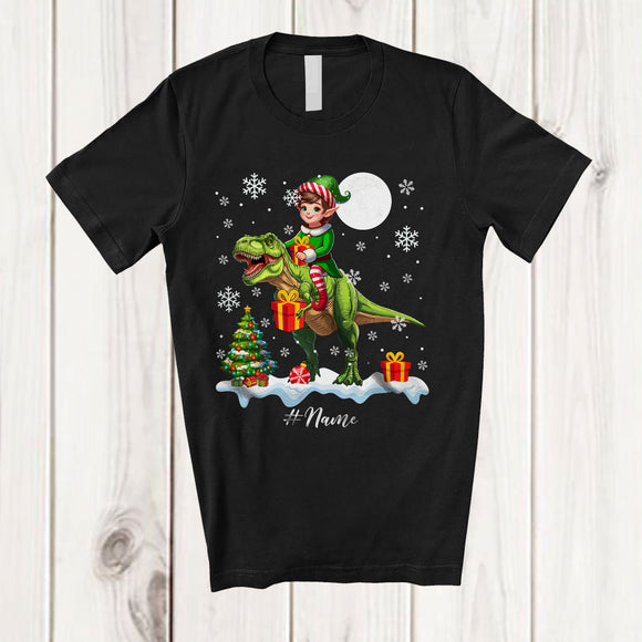 MacnyStore - Personalized Custom Name Elf Riding A T-Rex; Amazing Christmas Snowing T-Rex Wild Animal T-Shirt