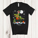 MacnyStore - Personalized Custom Name Elf Riding A T-Rex; Amazing Christmas Snowing T-Rex Wild Animal T-Shirt