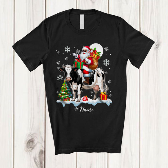 MacnyStore - Personalized Custom Name Santa Riding A Cow; Amazing Christmas Snowing Cow Farm Farmer T-Shirt