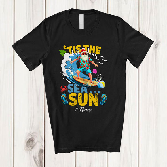 MacnyStore - Personalized Custom Name Tis The Sea Sun; Cheerful Christmas In July Summer Santa Surfing T-Shirt