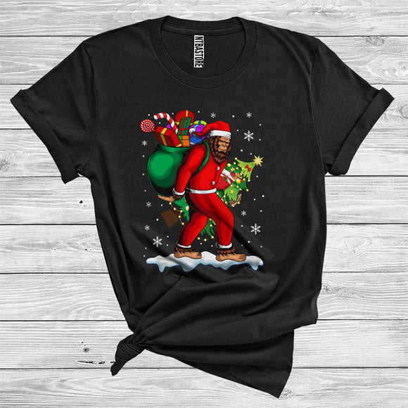 MacnyStore - Bigfoot Wearing Santa Costume Carrying Christmas Boxes Tree Cool Snowing Lover T-Shirt