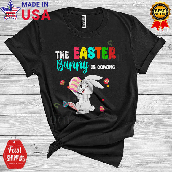 MacnyStore - The Easter Bunny Is Coming Cool Cute Easter Day Bunny Hunting Easter Eggs Flowers Lover T-Shirt